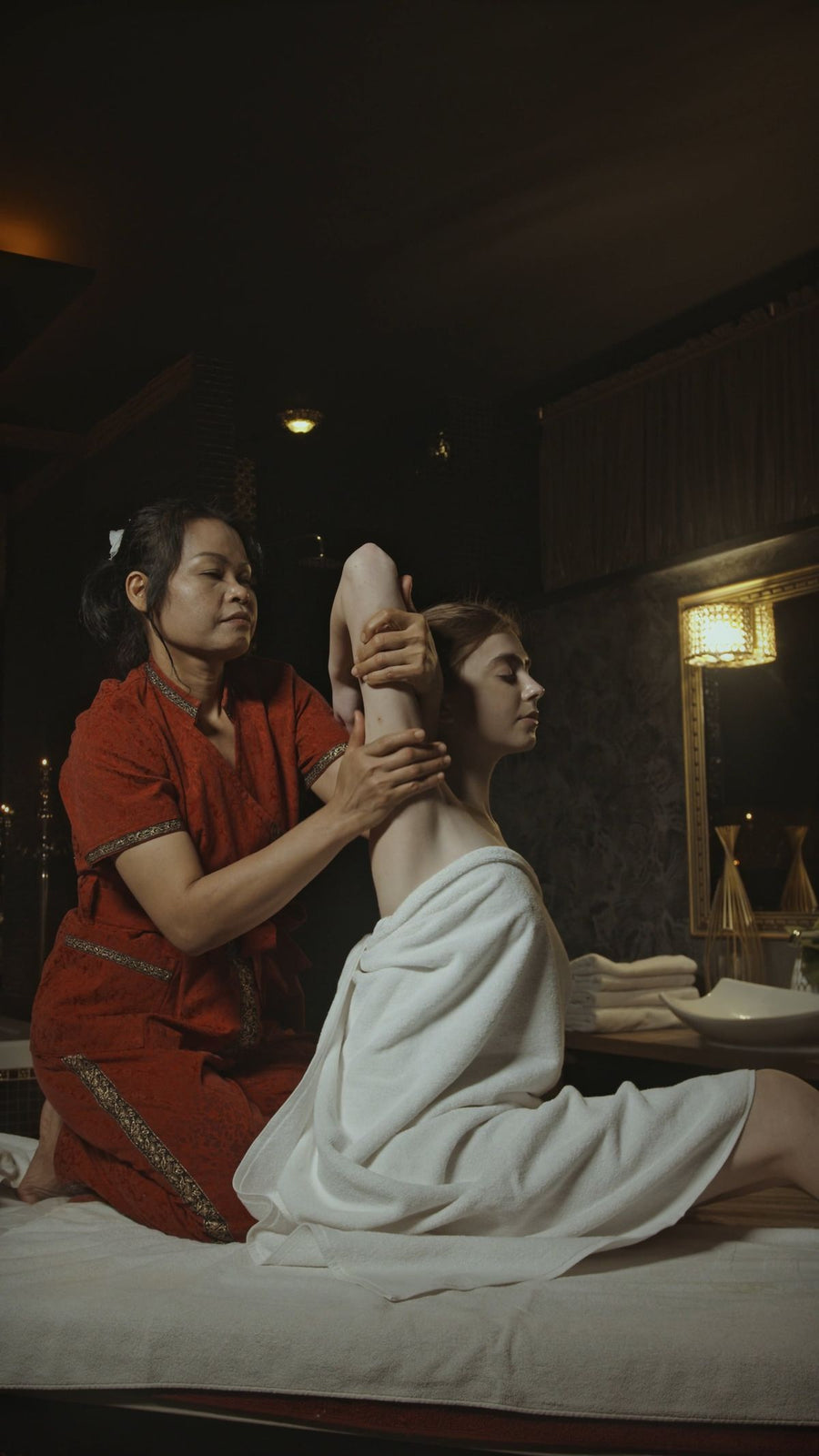 Traditionelle Thaimassage: Therapeutin dehnt sanft den Arm einer Kundin